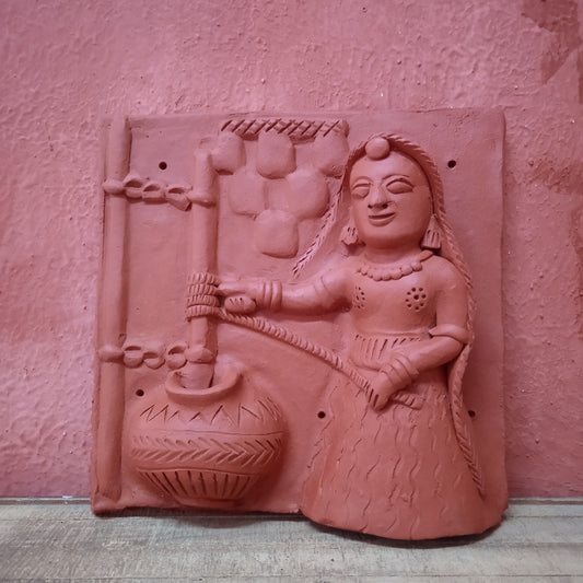 Terracotta woman churning milk